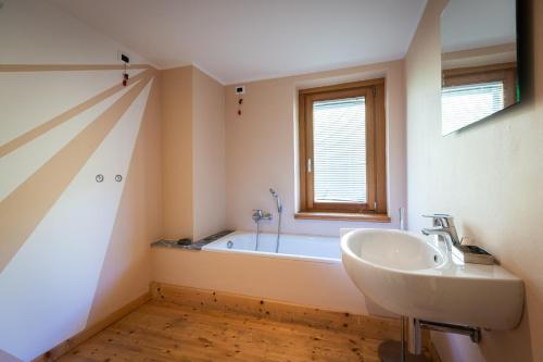 a bathroom with a sink and a bath tub at La Marmote Albergo Diffuso di Paluzza Aip in Paluzza