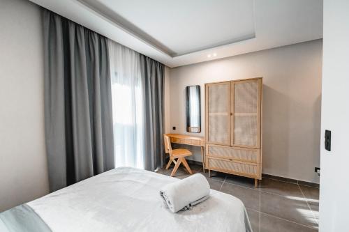 a bedroom with a white bed and a desk at Nima Suites Corfu in Marathias