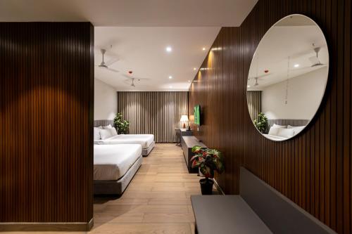 a hotel room with two beds and a mirror at Assembly By The Democracy in Nashik