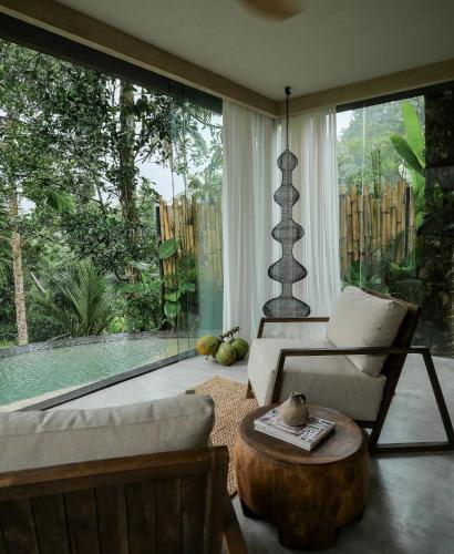 a living room with a couch and a table at Utopia Concept Bali - Adults Only in Ubud