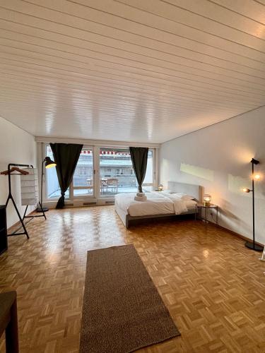 een grote slaapkamer met een bed en een groot raam bij Living Cozy in Bern in Bern