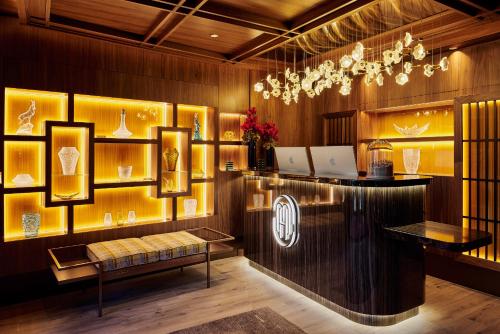 a lobby with a bench and a chandelier at Maya Hôtel Courchevel 1850 in Courchevel