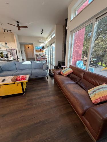 ein Wohnzimmer mit einer braunen Ledercouch in der Unterkunft Green Door Country Home Ein Zivan in Ein Zivan
