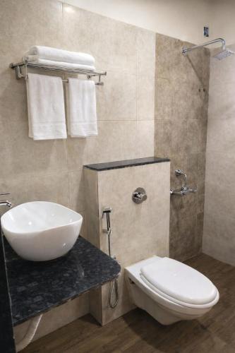 a bathroom with a sink and a toilet at Hotel Shree Abhishek in Bārāmati