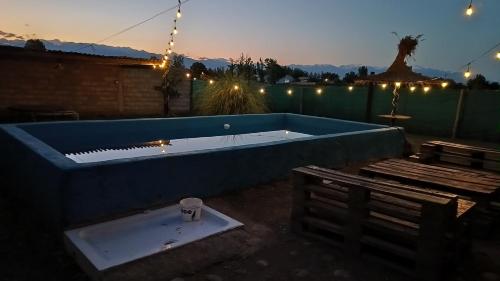 a swimming pool with a tub and a piano at Cabañas Rústicas Entre Montañas in Tunuyán