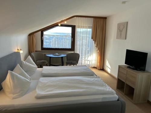a hotel room with two beds and a television at Hotel Panorama in Waldachtal