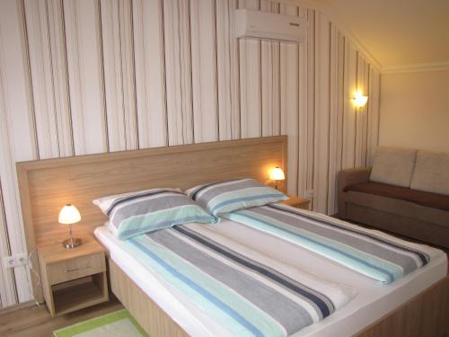 ハイドゥソボスローにあるCsilla apartmanのベッドルーム1室(大型ベッド1台、枕2つ付)