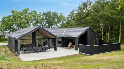 a house with a black roof and a patio at Villavilla 640 - Saksild, Østjylland in Odder