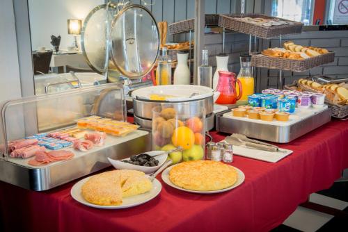une table avec des assiettes de nourriture sur une table rouge dans l'établissement Hôtel du Lion d'Or, à Marmande
