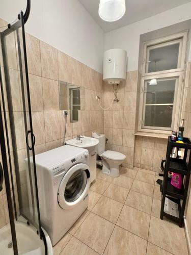 a bathroom with a washing machine and a toilet at Pokój przy Rynku ll in Katowice