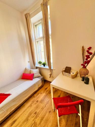 a room with a bed and a desk and a window at Pokój przy Rynku ll in Katowice