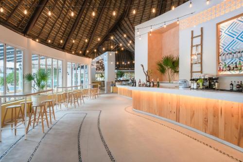 a restaurant with a bar and tables and chairs at Iberostar Selection Paraíso Lindo - All Inclusive in Puerto Morelos