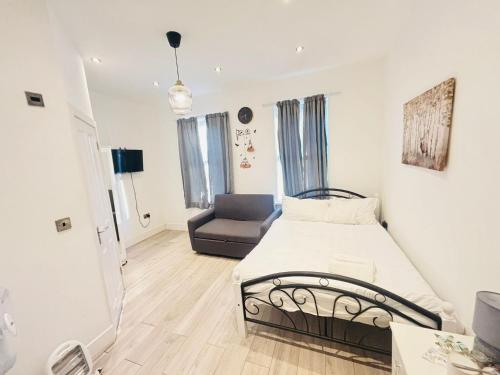 a bedroom with a bed and a couch in it at The Forest Residence in London
