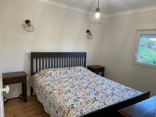 a bedroom with a bed with a colorful comforter at Relaxing Riverside Escape & Stunning Sunset Views in Santa Comba Dão