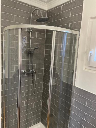 a shower in a bathroom with gray tiles at Relaxing Riverside Escape & Stunning Sunset Views in Santa Comba Dão