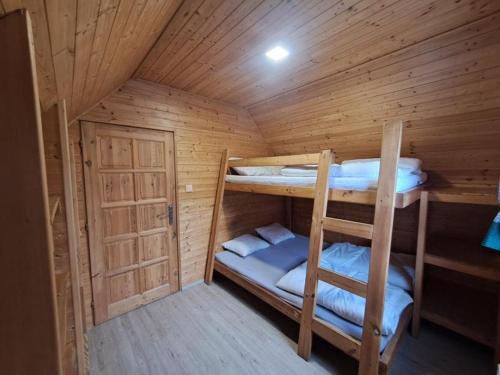 a room with two bunk beds in a wooden cabin at Chaty Hrubý in Dolní Moravice