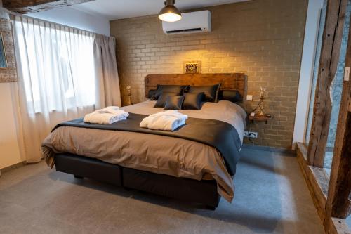 a bedroom with a large bed with two towels on it at les jardins de la ferme in Soumagne