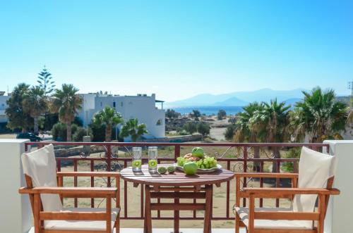a table with a bowl of fruit on a balcony at Perla Hotel in Agios Prokopios