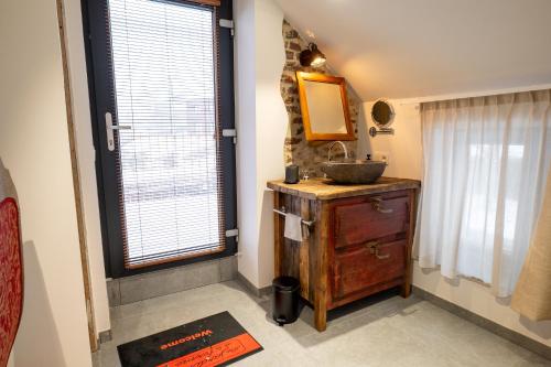 a bathroom with a sink and a mirror and a window at les jardins de la ferme in Soumagne