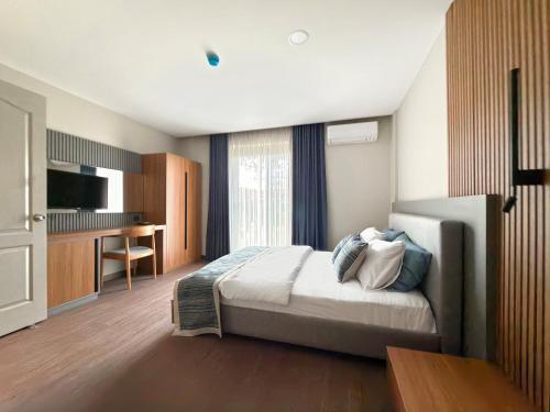 a bedroom with a bed and a desk in it at Silver Bay Club House in Urla