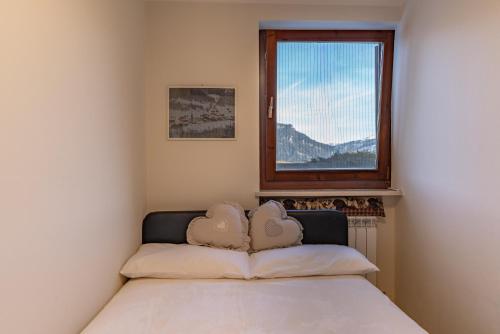 a bed in a room with a window at Trilo Ciasa Brìma in Carano