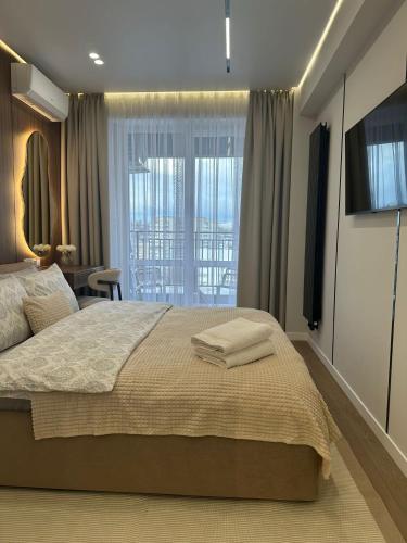 a bedroom with a large bed and a television at RentNow Apartments Luxury Apartment with Balcony and Parking in Chişinău