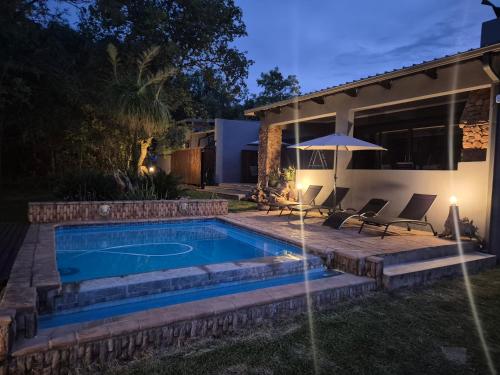 a swimming pool in the backyard of a house at night at Brett's Place in Warmbaths