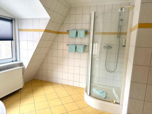 a bathroom with a shower with blue towels at Hotel BernsteinSee in Bitterfeld