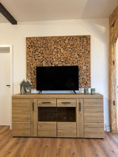 a television on a wooden cabinet in a living room at Stadtblick Ferienwohnung in Braunlage