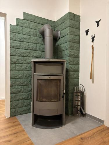 a fireplace in a room with a green brick wall at Stadtblick Ferienwohnung in Braunlage