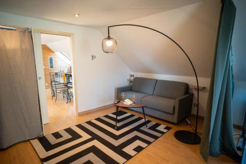 a living room with a couch and a table at Le Bollwiller Piscine Jacuzzi Vignoble in Bollwiller