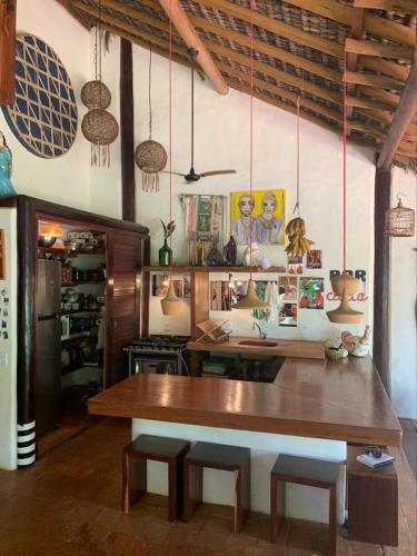 a room with a large wooden table in a room at Bangalô 12 in Porto Seguro