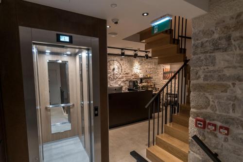 a hallway with a staircase leading to a kitchen at Murum Heritage Hotel in Split