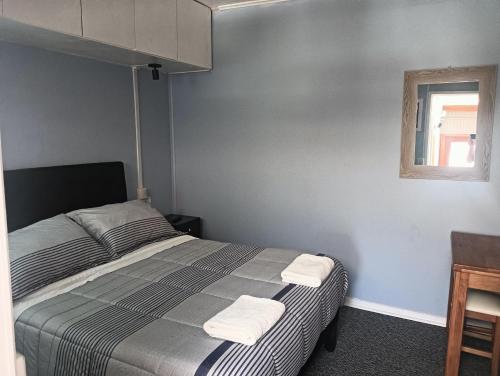 a bedroom with a bed with two towels on it at Hostal Don Francisco in Osorno