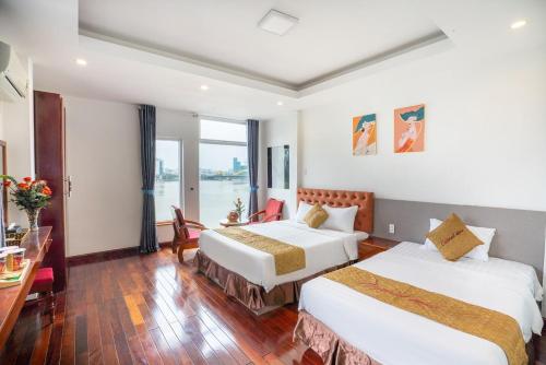 a hotel room with two beds and a table at Catinal Hotel in Danang
