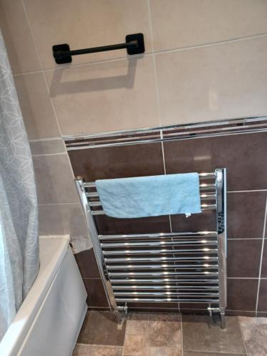 a bathroom with a towel on a towel rack next to a bath tub at Christian Guest House 1 in Luton