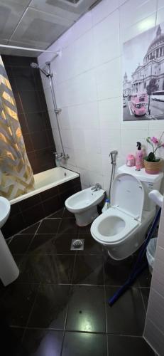 une salle de bain avec deux toilettes et une baignoire dans l'établissement Frank spaces, à Abu Dhabi