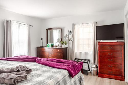 a bedroom with a bed and a tv and a dresser at ComfiNook Cozy Suburb Stay Philly Airport Parking