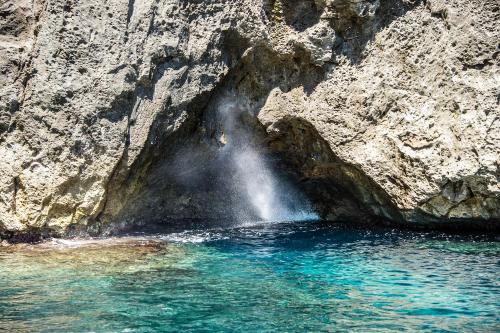 a waterfall on the side of a rocky cliff at Hotel Terminal - Caroli Hotels in Leuca