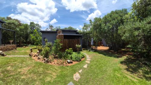 a backyard with a garden with a house at Brett's Place in Warmbaths