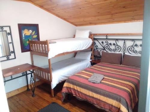 a bedroom with a twin bunk bed and a desk at Soloko Game farm in Kareedouw