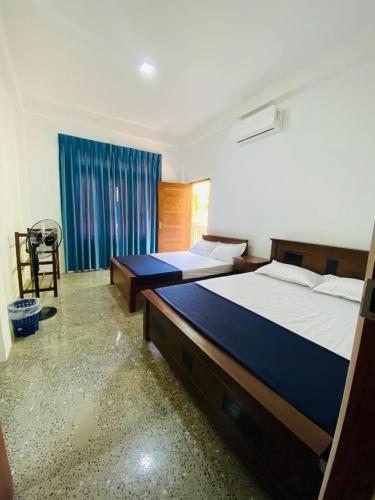 a bedroom with two beds and a window at Velora Resort in Anuradhapura