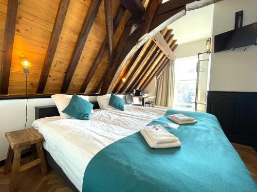 a bedroom with a large bed with blue sheets at Hector Zierikzee in Zierikzee
