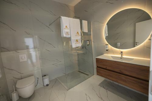 a bathroom with a toilet and a sink and a mirror at Hotel Allegra in Prishtinë