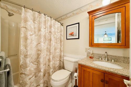 a bathroom with a toilet and a sink and a mirror at Saltwater Breeze in Wells
