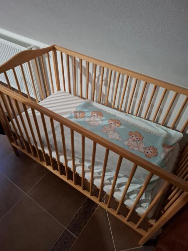 a wooden crib with a pillow on it at Apartmán Coralina in Zvolen