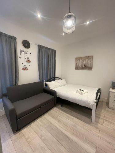 a small bedroom with a bed and a couch at The Forest Residence in London