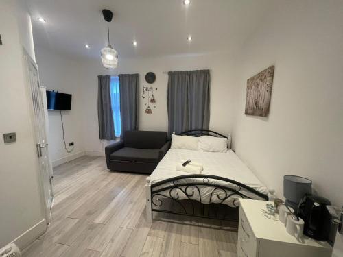 a small bedroom with a bed and a couch at The Forest Residence in London