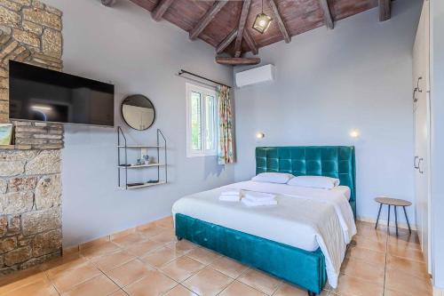 a bedroom with a bed and a flat screen tv at Villa Palataki II in Kardamyli