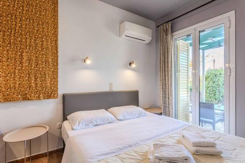 a bedroom with a white bed and a window at Villa Palataki III in Kardamyli